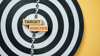 Wooden blocks with text Target Analysis placed on dartboard, representing strategy, performance...