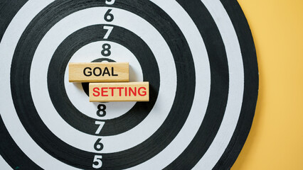 Target board with wooden blocks showing text Goal Setting, symbolizing achievement, motivation,...