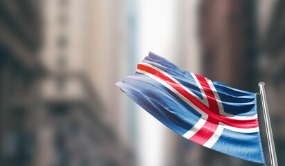 Iceland national flag waving on street. A beautiful with mast with blur buildings. Iceland national...