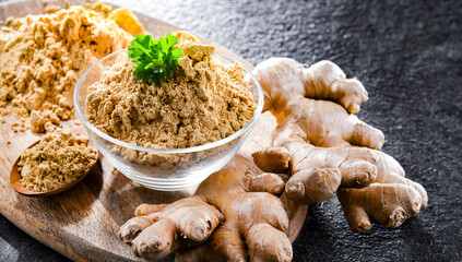 A bowl with ground ginger and its fresh rhizome