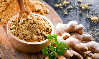 A bowl with ground ginger and its fresh rhizome