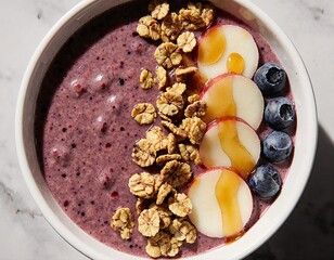 A vibrant and healthy breakfast bowl featuring a smoothie base topped with fresh fruit, granola, and drizzled honeyop