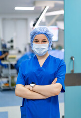 Surgical scrubs healthcare pro. A healthcare worker in blue scrubs and a mask stands confidently,...