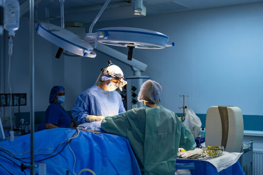 Modern surgery in OR. Two surgeons perform a complex operation in a well-equipped surgical suite during a hospital procedure.