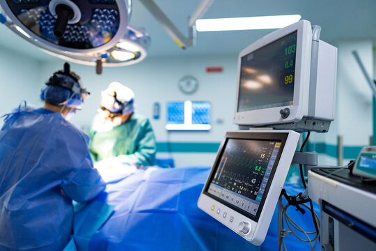 OR team during surgery. Medical professionals are performing a surgery in a modern operating room with advanced equipment and monitors. - Powered by Adobe