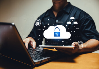 Cloud data protection concept. Businessman using laptop and tablet with secure virtual interface,...