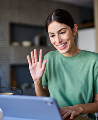 Portrait of a young woman  using tablet or laptop computer, having online meeting or browsing...