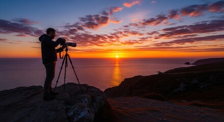 A photographer capturing a stunning sunset over the ocean from a rocky outcrop.