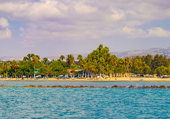 Mediterranean sea promenade with beach and touristic infrastructure under trees in city Paphos, Cyprus