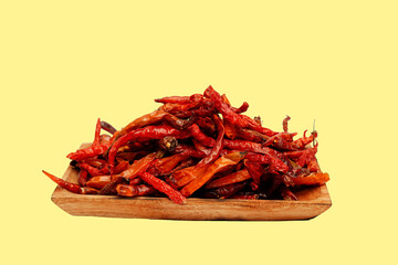 Fototapeta premium Dried chili pepper, chillies spicy served on wooden plate. Isolated on yellow background 
