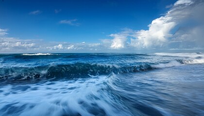 slow motion ocean waves moving toward shore under blue sky