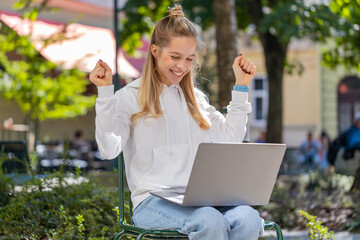Happy Caucasian woman freelancer working on laptop screams in triumph win celebrating good message...