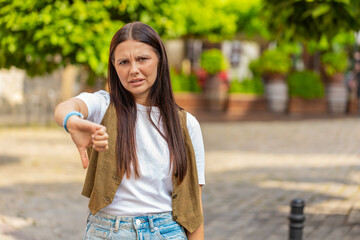 Dislike. Upset Caucasian young woman showing thumbs down sign gesture, expressing discontent...