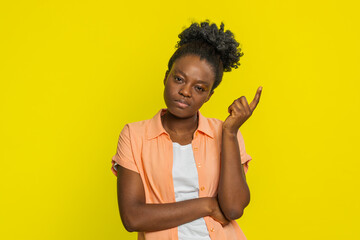 African American woman touches temple with finger, showing deep thought and focused expression....