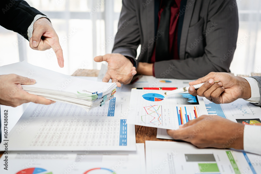 Poster three people are sitting at a table with papers and graphs in front of them