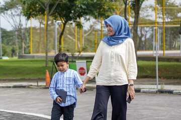 Fototapeta premium Mother and son holding hands while crossing the road, a moment of connection, walking in a safe environment, focus on family, portrait
