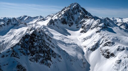 Obraz premium A vast, snow-capped mountain range stretches towards a brilliant, clear sky, showcasing rugged peaks and valleys filled with pristine white snow.