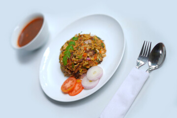 chicken with vegetables kottu roti plate with spoon, fork, gravy bowl.