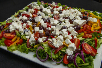 A large greek salad served on a white dish