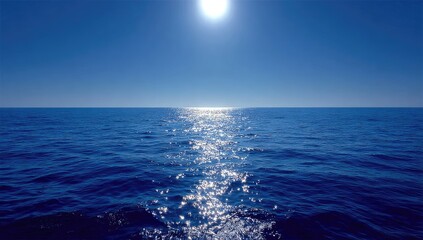 A vibrant blue ocean stretches to the horizon under a bright sun, its surface shimmering with reflected light