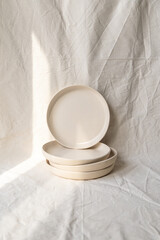 A set of handmade ceramic deep plates with a bowl like edge made from buff stoneware in a matt transparent glaze