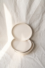 A set of handmade ceramic deep plates with a bowl like edge made from buff stoneware in a matt transparent glaze