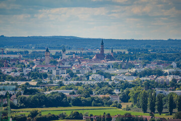 Blick auf eine Stadtlandschaft mit historischen Gebäuden und grünen Feldern in der Ferne an einem...
