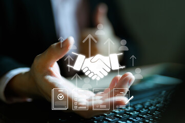 Professional hands protecting handshake icon with business documents and people symbols floating above laptop. Partnership agreement and business relationship management concept visualization.