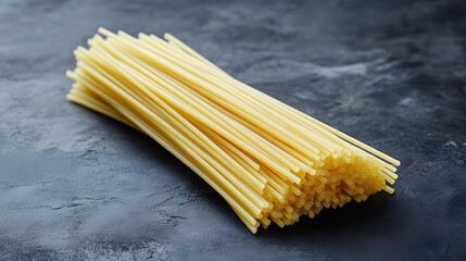 Spaghetti noodles loosely bundled on a dark backgroud, emphasizing their fine,smooth texture and organicshape.