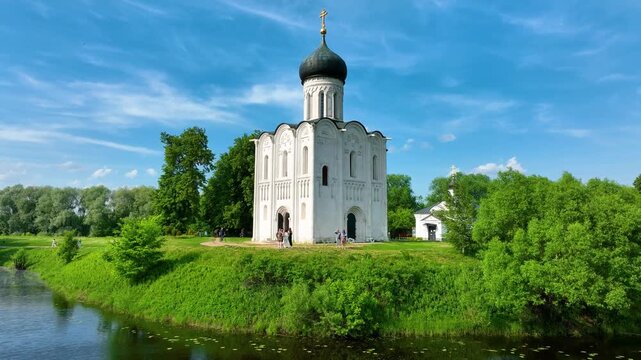 Bogolyubova, Russia - May 13, 2024: A high-angle drone shot of the Church of the Intercession on the Nerl, located at the bend of a river surrounded by lush green meadows