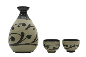 Elegant ceramic sake set with a tan body and black abstract floral design, two cups included. background removed