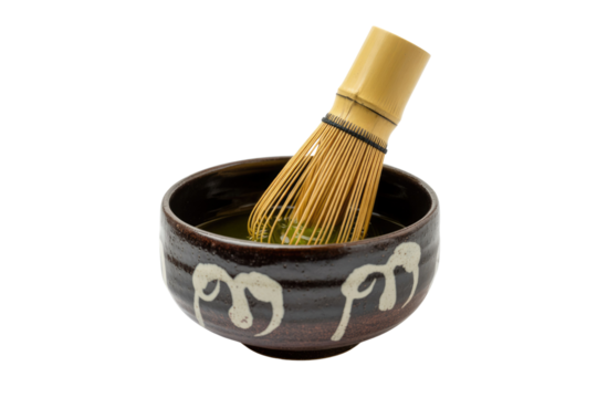 A matcha whisk inside a dark brown bowl with white designs, preparing a vibrant green matcha tea. background removed