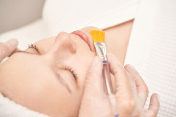 Female spa facial treatment with skincare mask application by esthetician in relaxing environment.