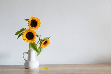 summer bouquet with sunflowers in white jug  on wooden table