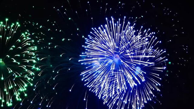 Pyrotechnic display exhibiting vibrant hues of emerald and cerulean