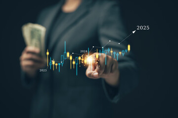 Businessman or investor is holding money and choosing to buy stocks that have a chance to grow in 2025. Stock chart on the screen is always real. Investing in stocks for the long term.