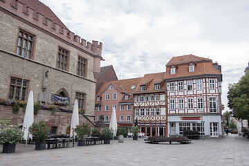 Historic half timbered houses and stone building with outdoor café on central square in Göttingen, Germany