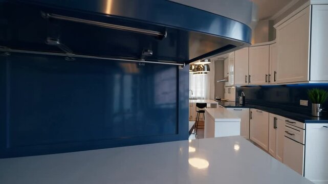 Sleek and Contemporary Culinary Space Featuring Blue Central Island and White Storage Cabinets