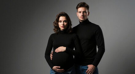 Pregnant woman with partner in black turtlenecks studio portrait. Minimalist maternity session for prenatal care services and family planning documentation