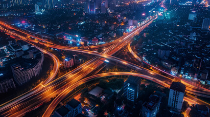Aerial capture of a bustling city at night reveals intricate road networks illuminated by glowing lights from moving cars. The vibrant streets exhibit a dynamic urban lifestyle and traffic flow