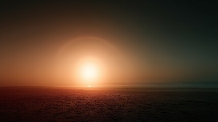 Fototapeta premium Peaceful sunrise view with glowing horizon and calm ocean waves, casting warm light across a quiet sandy beach.