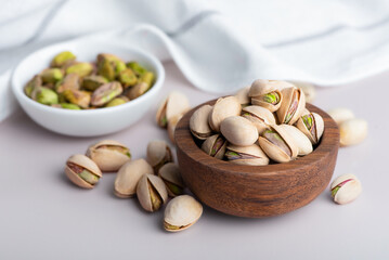 Pistachio nuts in shell. Healthy Snack Rich in protein. Pistachios in a wooden bowl and scoop.