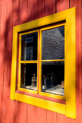 Obraz premium Old window of Swedish wooden house in orange and red