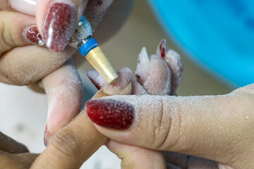 Fototapeta premium Nail treatment - gel nail removal in salon, close-up view