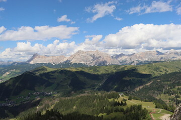 Trentino, Italy - July 29, 2025: Panoramic view of the majestic Piz Boe and the surrounding Dolomite peaks, with lush green valleys and scattered snow, under a clear blue sky. beautiful view to Lake b