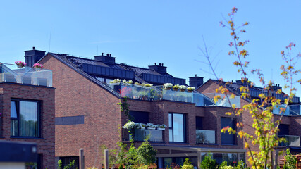 Harmony with nature, eco architecture. Terraced single family homes in newly developed housing estate. The real estate market in the suburbs with lush greenery surrounding. 