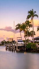Obraz premium Canal sunset with palm trees and boat