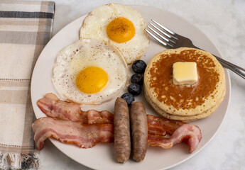 fried eggs wih pancakes and sausages