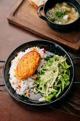 Healthy lunch with vegetable cutlet, rice and green salad on wooden table
