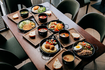 Assorted traditional European meals with soups, salads, and main courses on wooden trays
